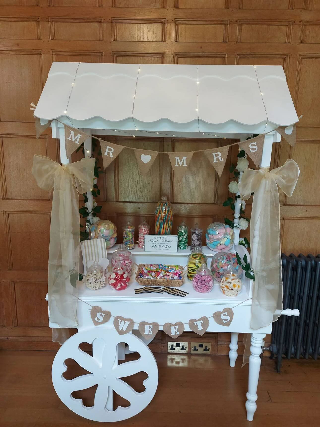 White wedding sweet cart with sweets and decorations